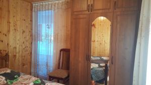 苏呼米Частный сектор的一间卧室配有两张床、一把椅子和镜子
