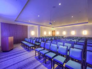 格林威治格林威治J公馆酒店的一间会议室,配有蓝色椅子和讲台