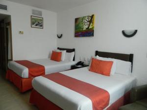 夸察夸尔科斯Hotel Enriquez的酒店客房带两张床,橙色和白色