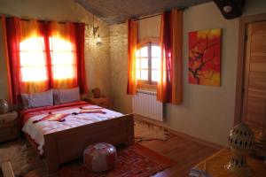 伊夫兰La pommeraie d'Ifrane的一间卧室设有一张床和两个窗户。