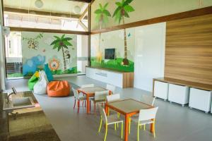 嘎林海斯港Oka Resort的一间设有桌椅的房间和一间种植了棕榈树的房间