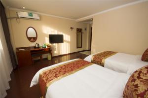 天津格林豪泰天津宾水道肿瘤医院快捷酒店的酒店客房配有两张床和一张书桌