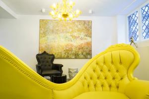 马德里马德里沃尔特旅馆的客厅里一张黄色的沙发,上面有绘画作品