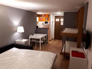 布勒伊-切尔维尼亚Matterhorn Studio Cervinia的小房间设有床、桌子和厨房