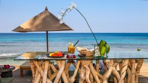 圣吉吉Qunci Villas Resort的海滩上的桌子和饮料