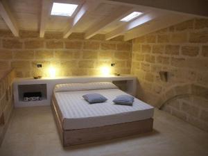 米内尔维诺迪莱切B&B Masseria Dei 12 Granai的一间卧室配有一张带两个枕头的床