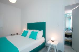 帕罗奇亚Acqua Vatos Paros Hotel的一间卧室配有一张带蓝色和白色枕头的床