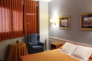 Tona蒙特塞拉特旅馆的配有一张床和一把椅子的酒店客房