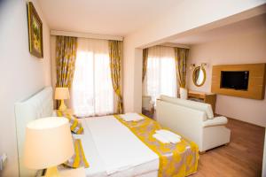 居姆贝特Ladonia Hotels Del Mare的酒店客房配有床、沙发和电视。