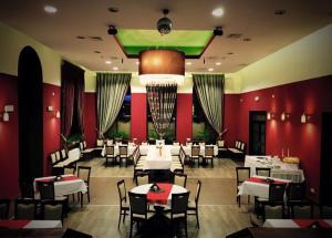 希隆斯克地区宗布科维采Dolnośląski的一间设有白色桌椅和红色墙壁的餐厅