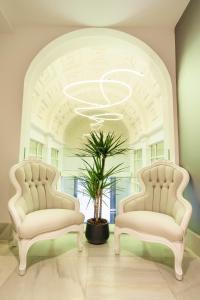 马德里马德里沃尔特旅馆的天花板的房间设有两把白色椅子