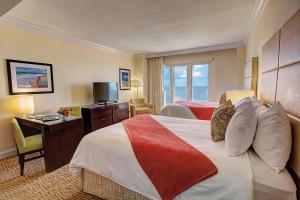 迈阿密海滩海景酒店的酒店客房设有两张床、一张桌子和一台电视。