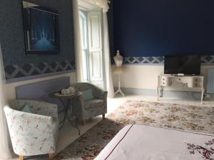 Stranocum花园谷庄园宅邸住宿加早餐酒店的蓝色的客厅配有椅子和电视