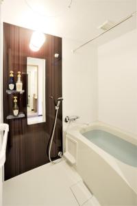 札幌札幌奈茨酒店的带浴缸和镜子的浴室
