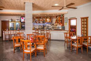 卡里尼奥Pension Restaurante Cantábrico的一间带木桌椅的餐厅和一间酒吧