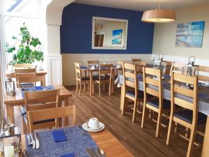 佩恩顿Channel View Boutique Hotel - Adults Only的一间配备有桌椅的用餐室和蓝色的墙壁