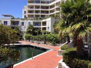 开普敦005 Marina Apartment的一座大型公寓楼,设有游泳池和棕榈树