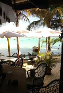 博卡奇卡船屋酒店的海滩上的桌椅和遮阳伞