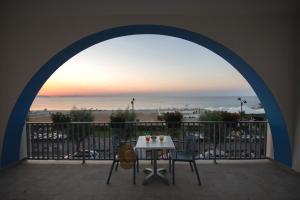韦内蒂科Karma Resort的海滩景阳台配有桌椅