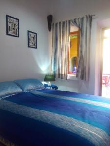 提兹尼特Riad Le Lieu的一间卧室配有一张带蓝色毯子的大床