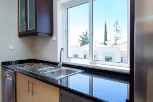 卡巴纳斯·德·塔维拉For Sea Apartment的厨房设有水槽和窗户。
