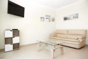 卡巴纳斯·德·塔维拉For Sea Apartment的带沙发和玻璃茶几的客厅