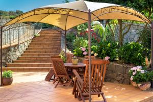 贝加德圣马特奥La Casa Del Campo的露台配有桌椅和遮阳伞