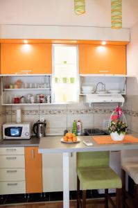 弗尔尼亚奇卡矿泉镇莉娜公寓的厨房配有橙色和白色的橱柜和桌子