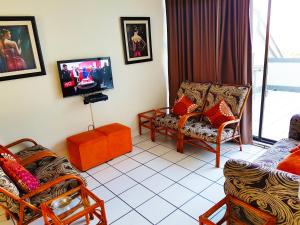 马盖特Dumela Margate Flat 21的客厅配有椅子和平面电视