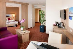 汉堡汉堡沃尔克斯公园美居酒店 的酒店客房设有床和客厅。