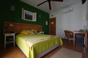 明德卢基拉精品酒店的一间卧室配有一张带绿色墙壁的床