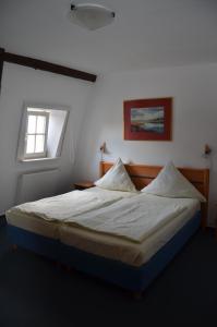 巴本豪森黑狮酒店的卧室配有一张带白色床单的大床和窗户。