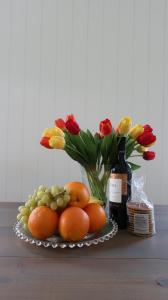 阿姆斯特丹吉娜花园别墅公寓的果盘和鲜花以及一瓶葡萄酒