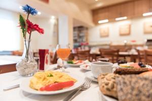伍珀塔尔伍珀塔尔瑞斯德酒店的餐桌,盘子和一杯橙汁