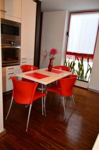 丰沙尔vista dos arrifes的餐桌、红色椅子和花瓶