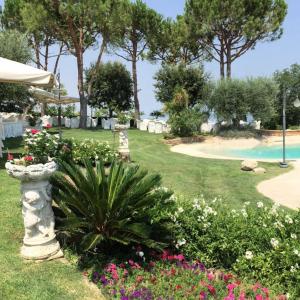 科隆内拉Le camere di Villa Incanto的鲜花盛开的花园和游泳池