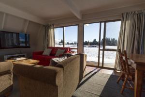 特卡波湖Arosa - Lake Tekapo的客厅配有红色的沙发和桌子