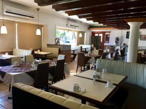 库利亚坎Hotel del Valle的一间带桌椅的餐厅和一间用餐室