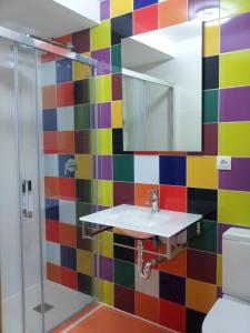 圣塞瓦斯蒂安圣费尔明膳食公寓的色彩缤纷的浴室设有水槽和淋浴。