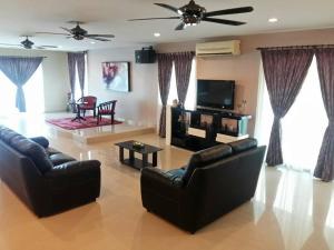 波德申Port Dickson Holiday Home Villa的客厅配有2张沙发和1台平面电视