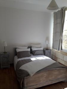 布莱Entre Estuaire et Citadelle的白色卧室配有带枕头的大床
