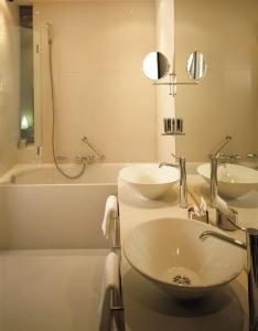 因戈尔施塔特考尔特酒店的浴室配有盥洗盆、浴缸和盥洗盆
