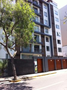 利马Departamento Miraflores的前面有棵树的建筑