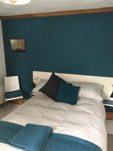 伦敦德里Erin Cottage的一间卧室配有一张蓝色墙壁的床