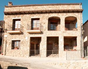 Rebollar卡萨普利亚乡村民宿的一座石头建筑,旁边设有阳台