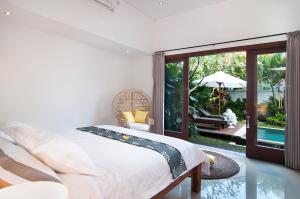 克罗柏坎3BR Villa Erja - Minggu Villas的一间卧室配有一张床,享有游泳池的景色