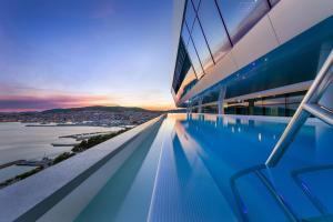 沃迪切Hotel Olympia Sky的一座享有日落美景的建筑屋顶上的游泳池