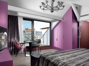 斯特拉斯堡勒月公寓的卧室设有紫色墙壁和桌椅