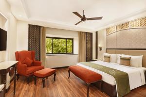 勒克瑙拉普诶斯珀尔提克萨罗瓦尔酒店的配有一张床和一把椅子的酒店客房