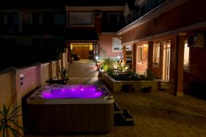 瓦茨星级旅馆的庭院内的一个热浴盆,晚上有紫色的灯
